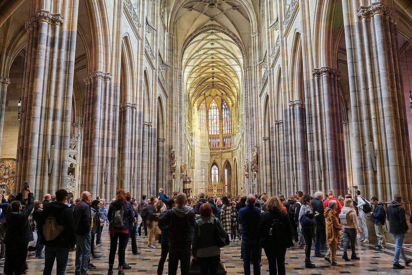 Guide explaining the facade of Notre-Dame Cathedral to a small group on the parvis