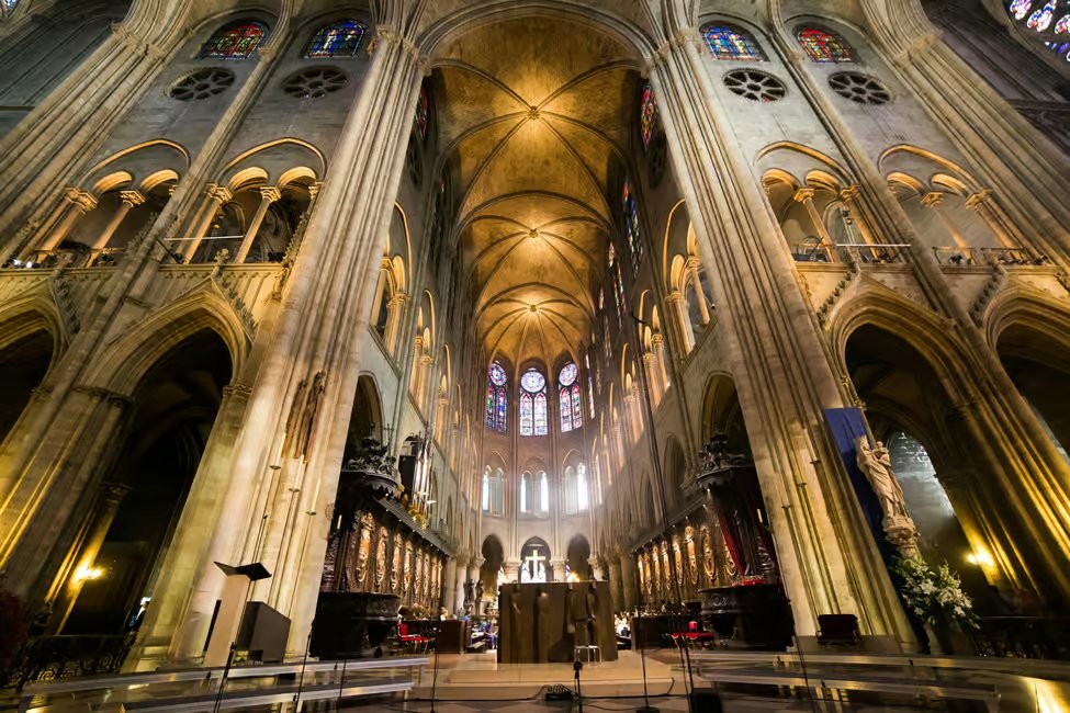 Local licensed guide pointing out stained glass detail inside Notre-Dame Cathedral